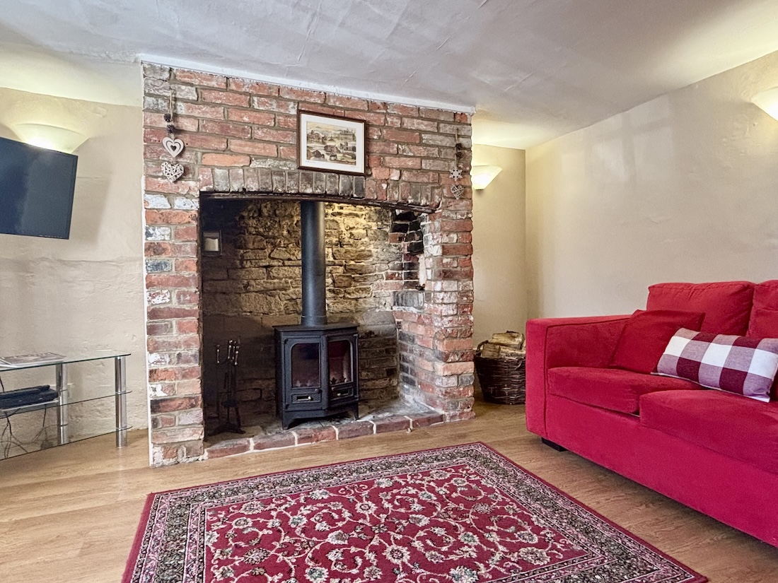 Relax in the delightful sitting room with stunning fire place and wood burner